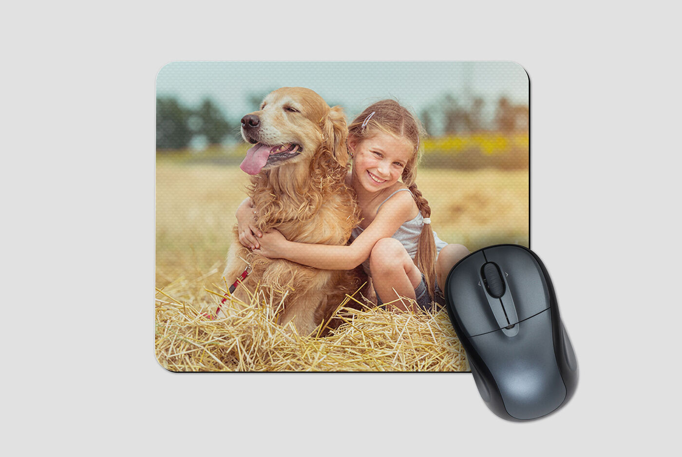 En flicka kramar sin gulliga hund på en åker med halm. De njuter av stunden tillsammans.