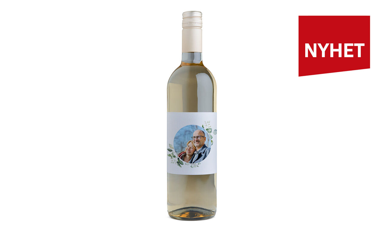 Flaska med mousserande vitt vin och vacker etikettdesign.