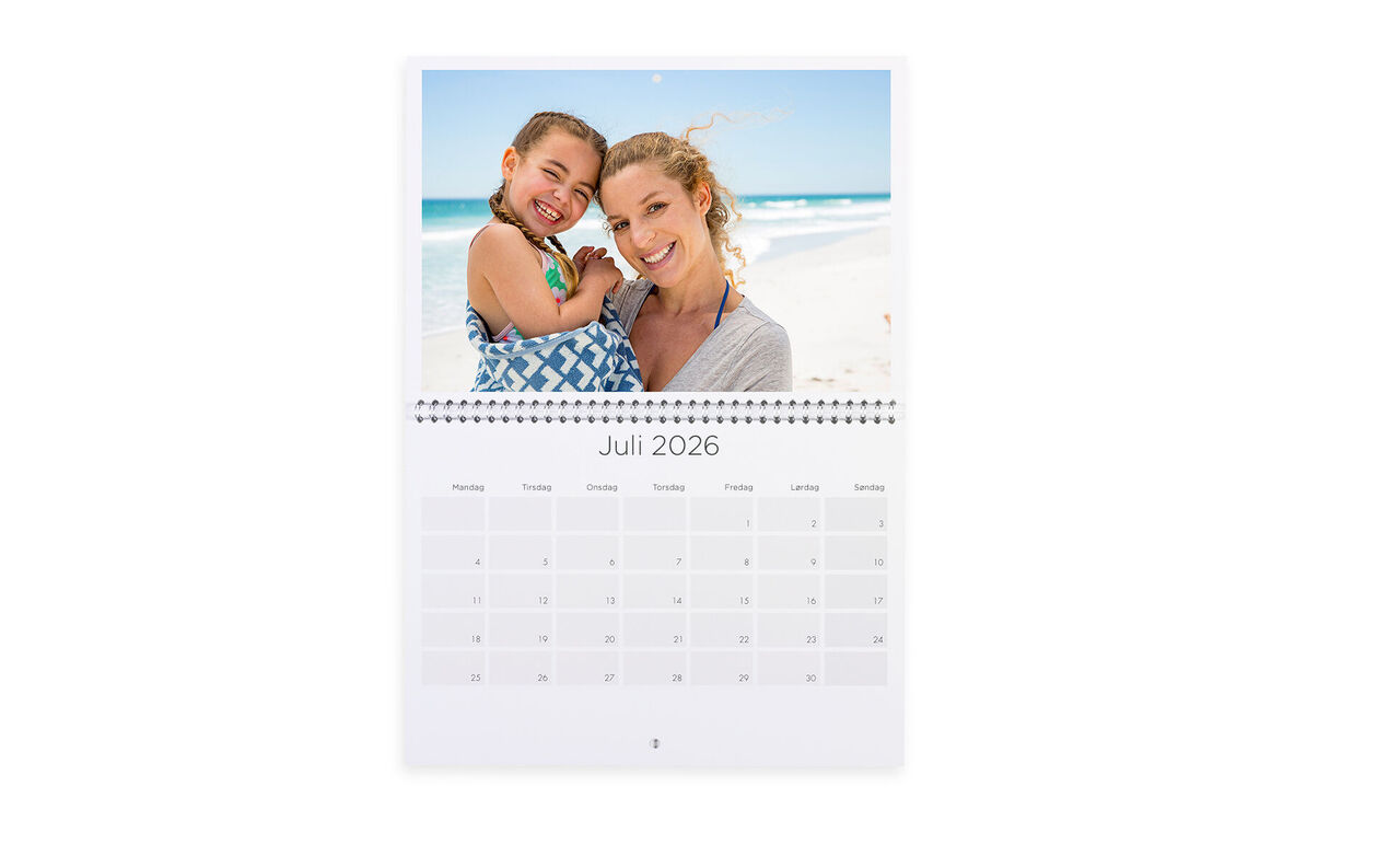 En färgglad fotokalender för juli 2025 med en glad mamma och hennes barn på stranden.