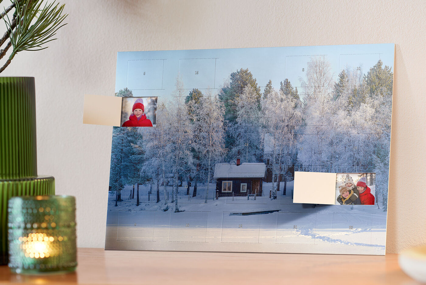 En vacker snöbakgrund med ett litet rött trä hus, omgiven av snöiga träd. Några bilder är placerade på bilden.