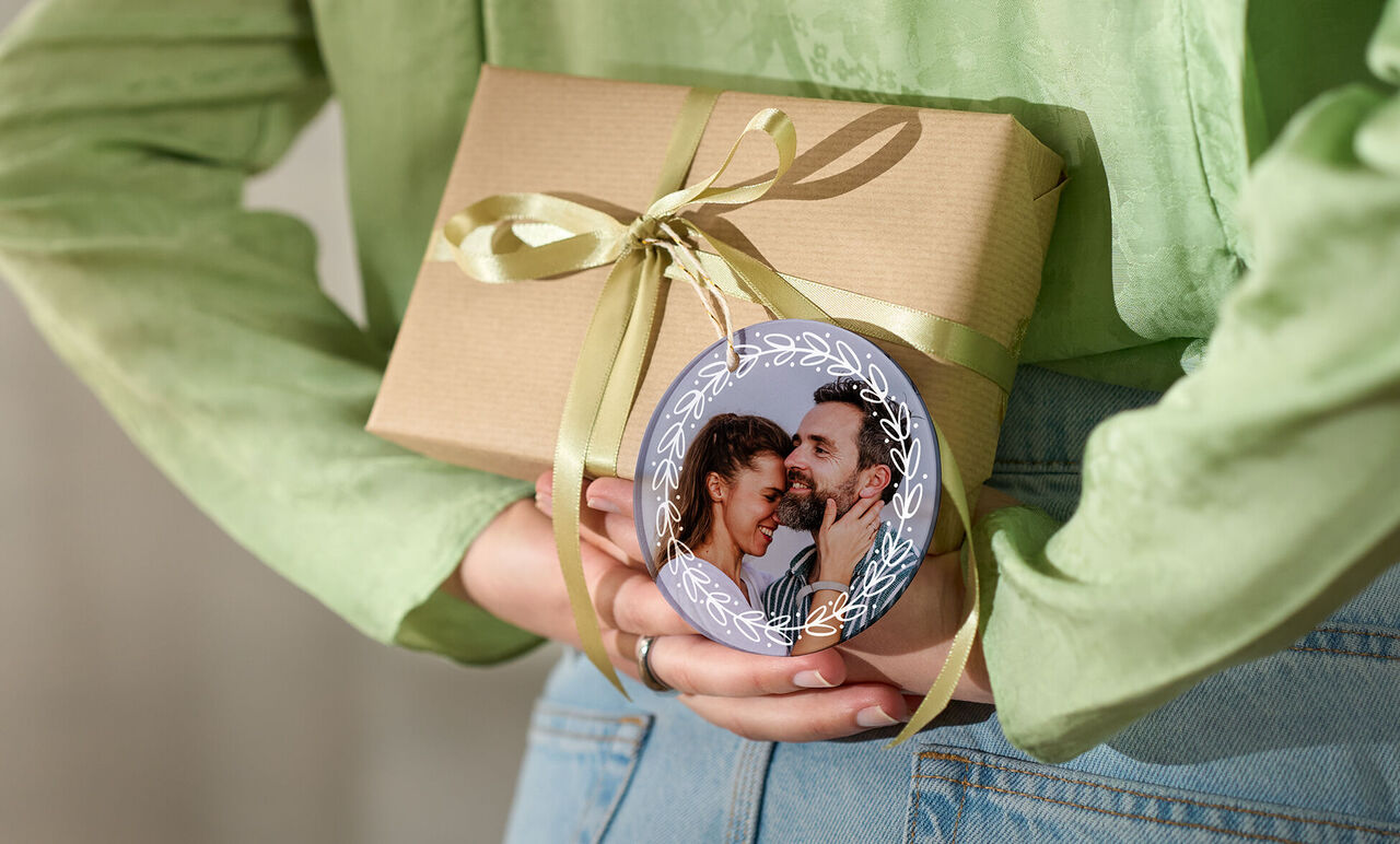 Present med ett band och ett runt ornament med ett foto.