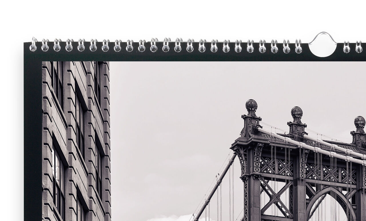 En högkvalitativ CEWE fotokalender visar en svartvit bild av Brooklyn Bridge med en byggnad i förgrunden.