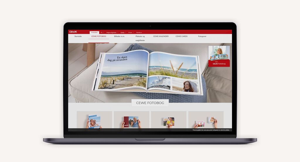En person bläddrar genom en öppen CEWE FOTOBOK med semesterbilder på en laptop.