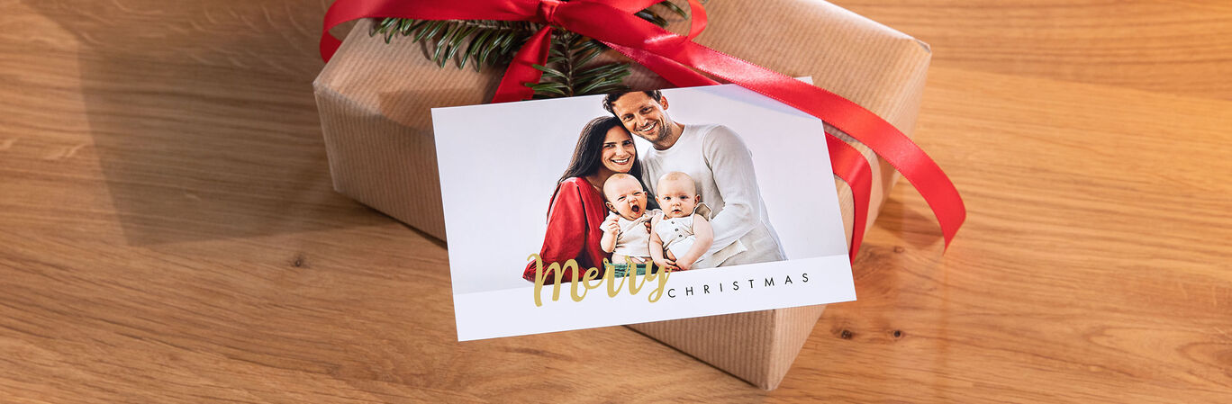 Familj med två barn bredvid ett presentpaket.