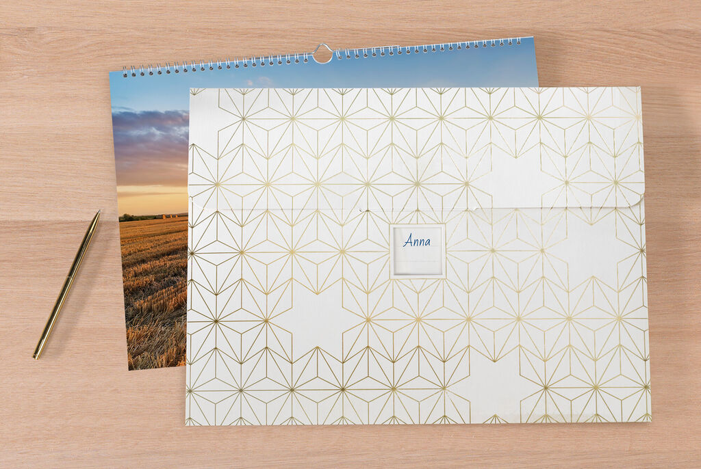 En stilren CEWE-fotokalender med ett modernt, gult geometriskt mönster.