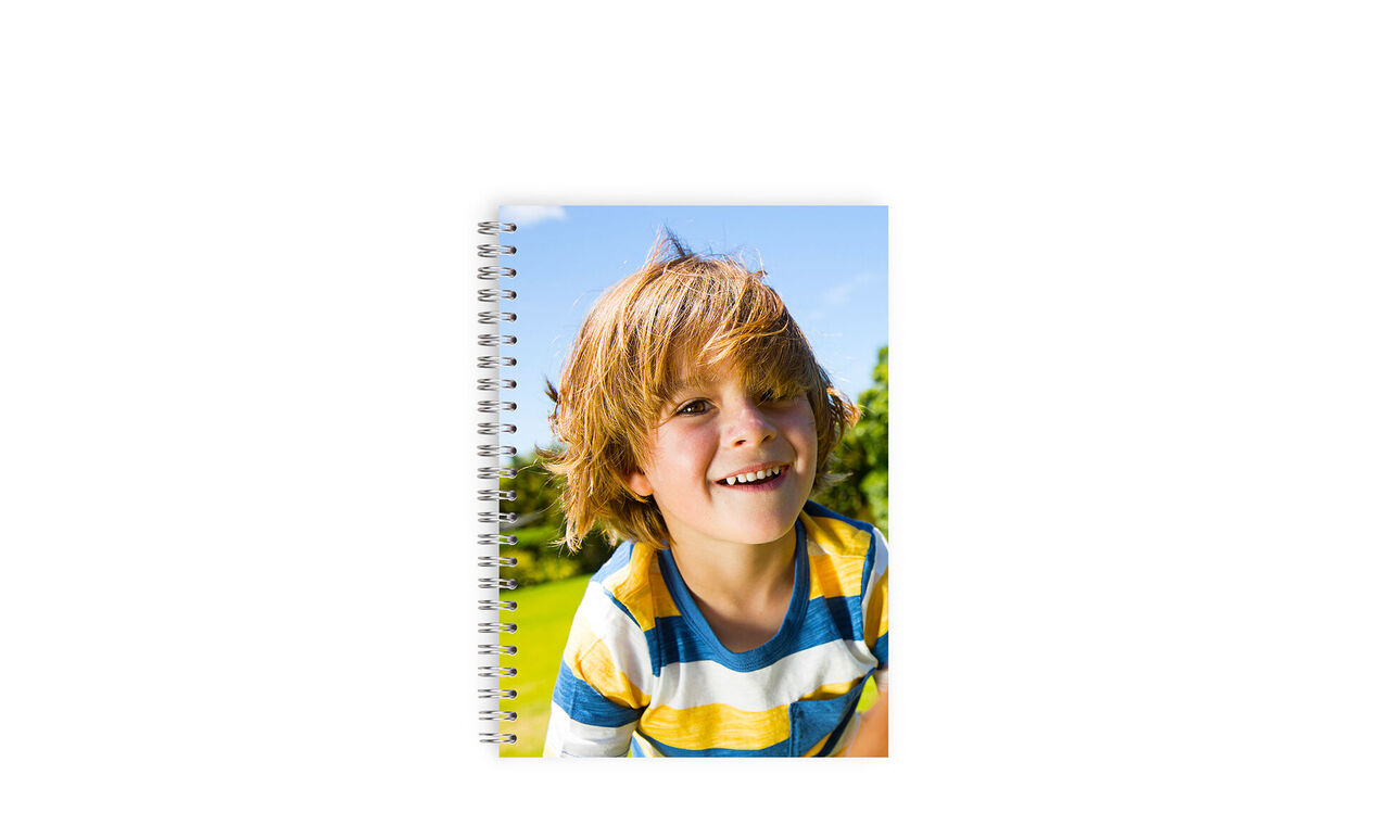 Ett glatt barn med en personlig anteckningsbok i handen, omgiven av natur.