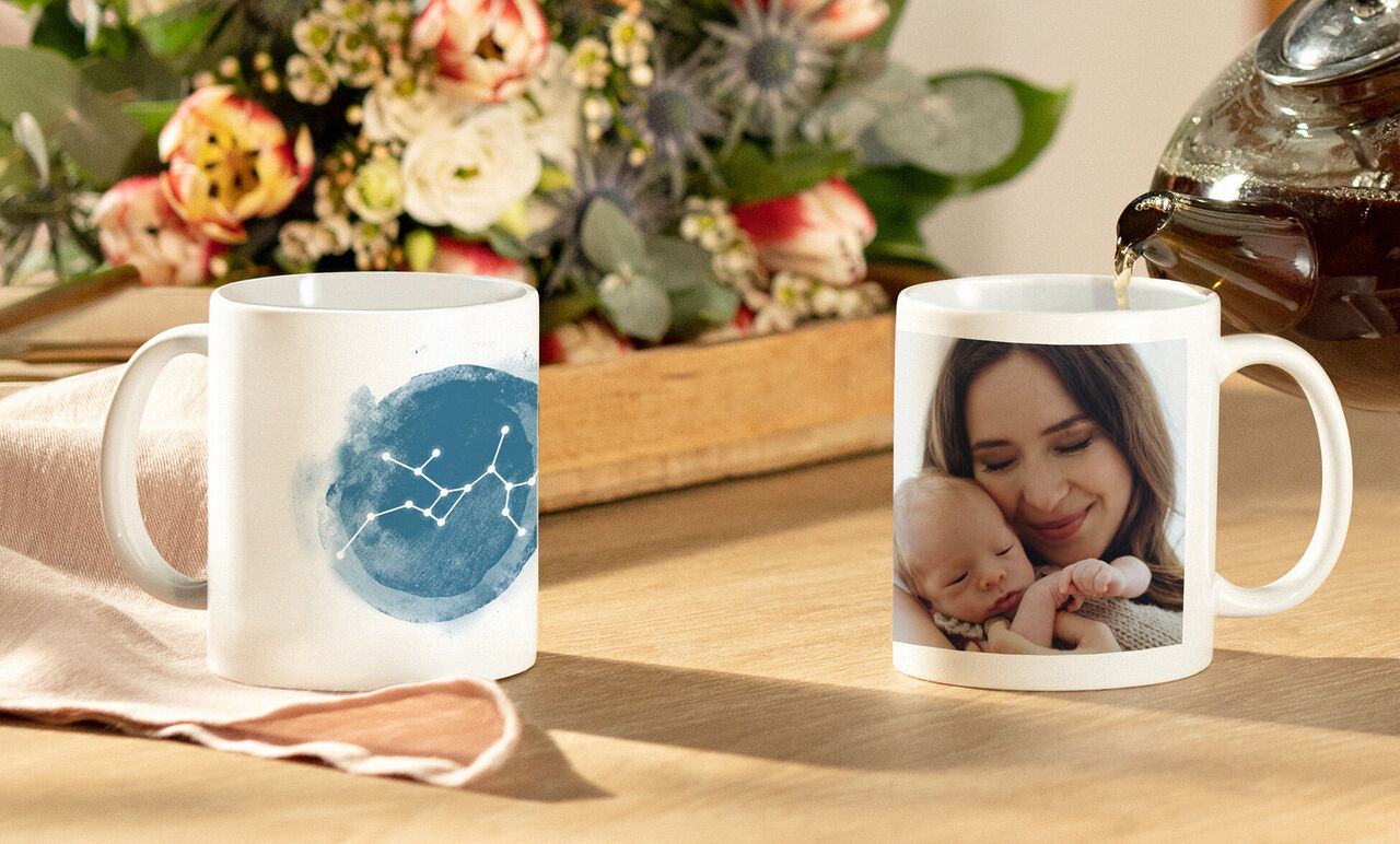 Personer njuter av en mugg med en individuell design, omgivna av blommor.