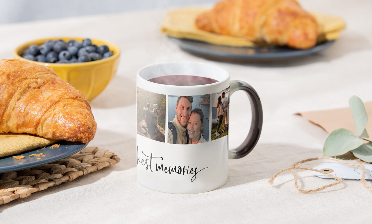 En mugg med foton av minnen, med croissanter och blåbär bredvid