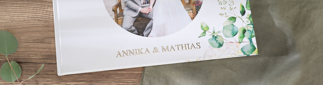 En elegant CEWE fotobok med namnet "Annika & Matthias" och blommönster.