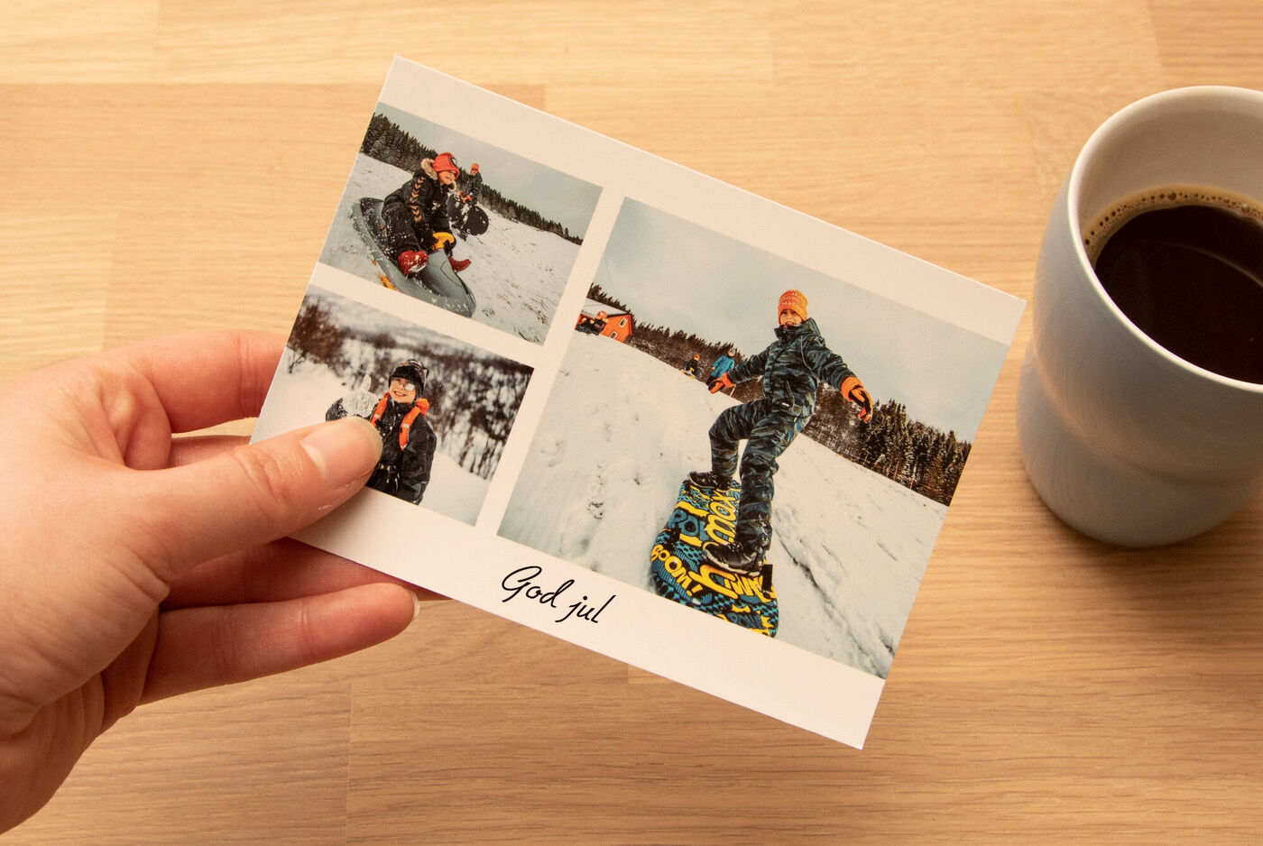 En person håller ett julkort med bilder på en snowboardåkare.