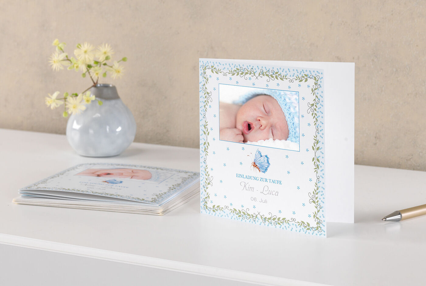Ett sött gratulationskort för en nyfödd med blå design och en bild på sovande baby.