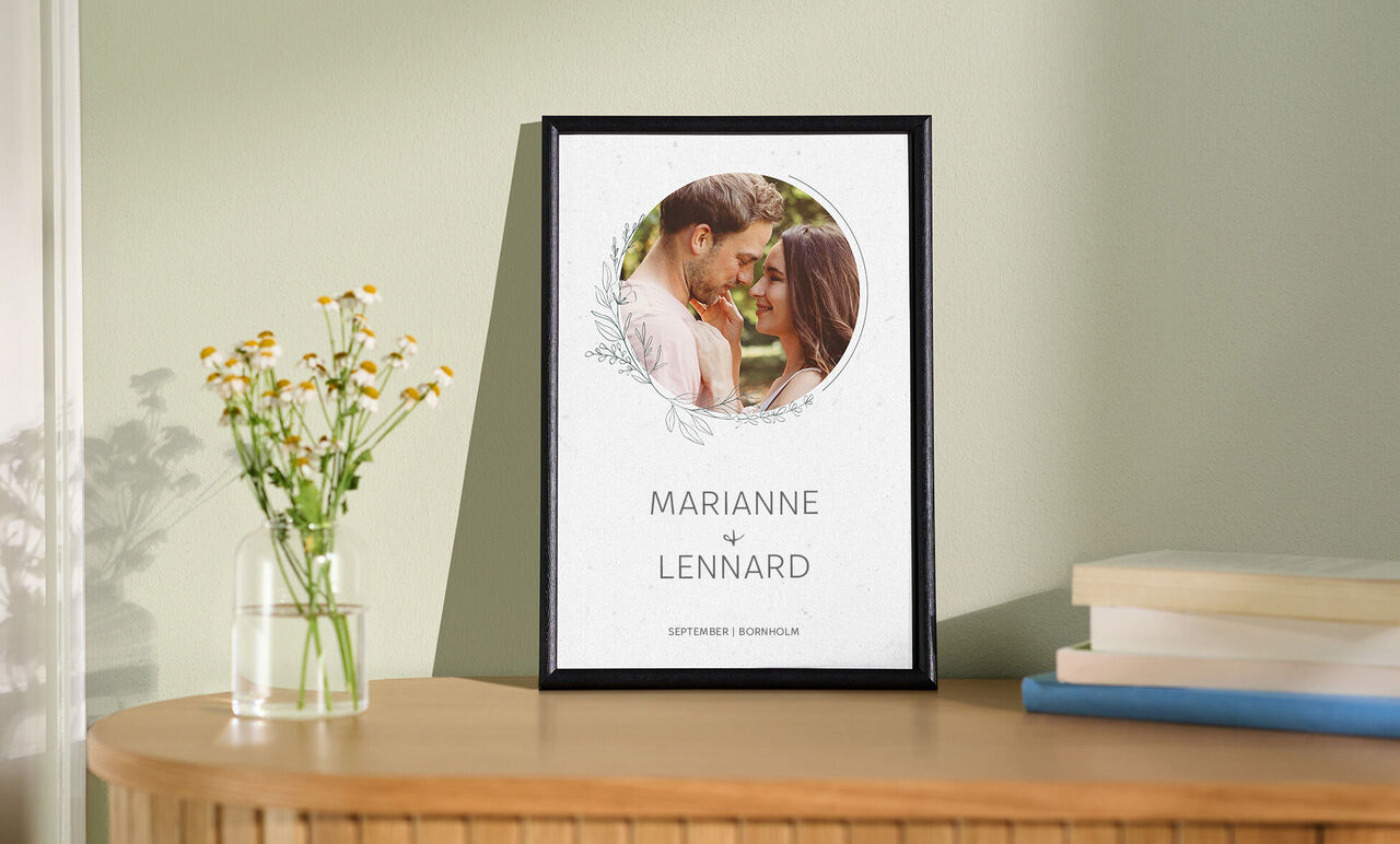 En planterad ram med namnen Marianne och Lennard, omgiven av blommande växter.