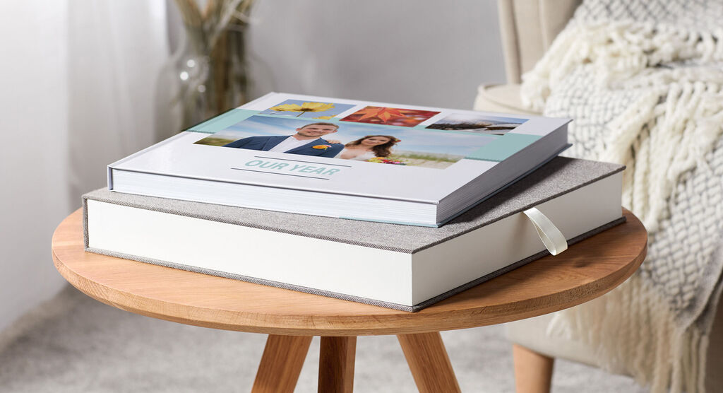 Två kärleksfullt designade CEWE fotoböcker på ett bord, som visar minnen.