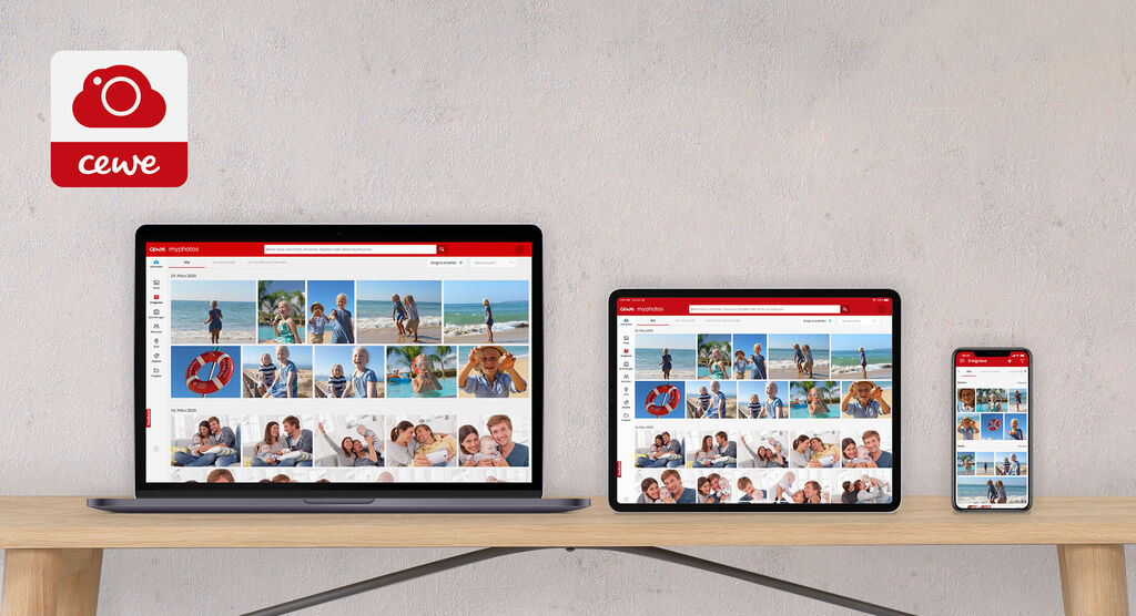 Två laptops och en smartphone visar CEWE fotovärld-app på ett bord.