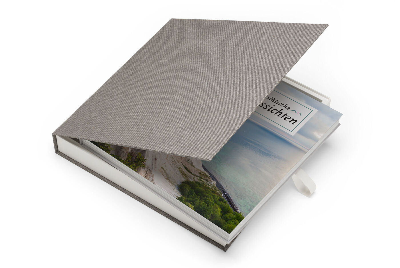 En elegant CEWE FOTOBOK med grått tygomslag och tittfönster visar ett färgglatt landskapsfoto.