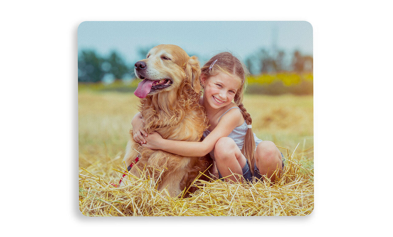 Ett barn kramar en golden retriever på en fin äng.