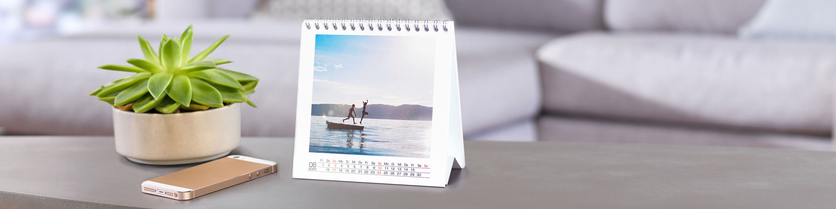 Vackert bord med en CEWE fotokalender och en växt.
