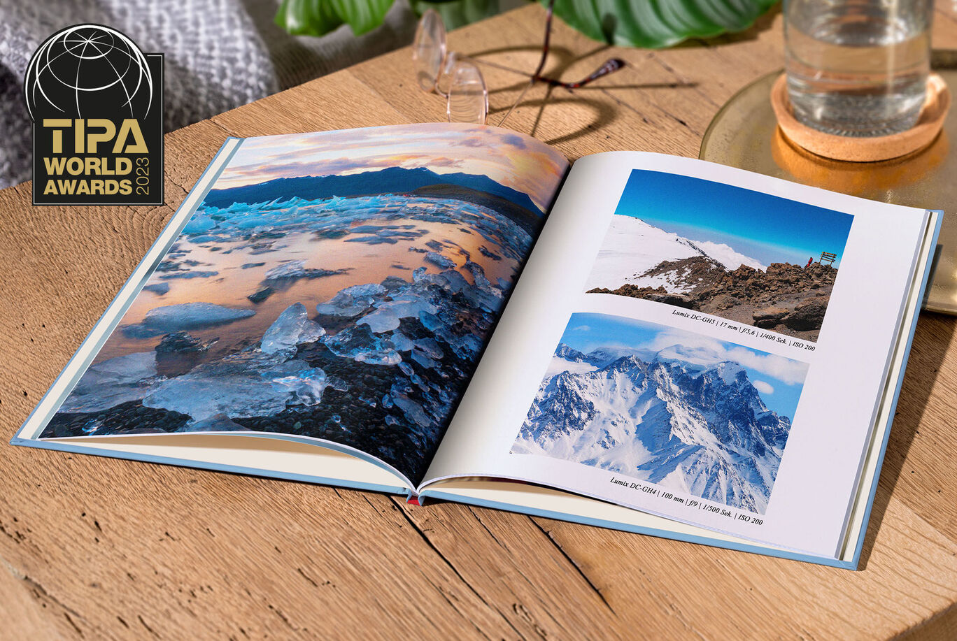 CEWE fotobok med bilder av berg och en sjö på ett träbord.