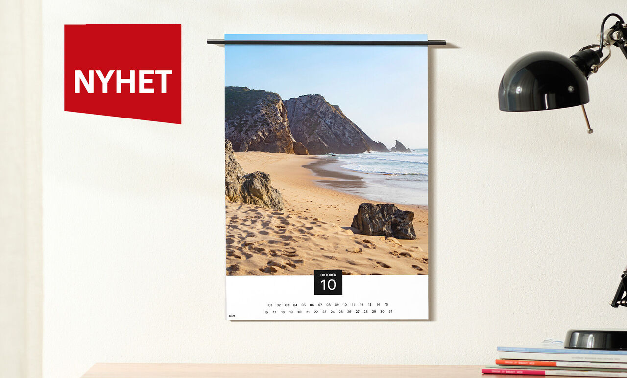 Hängare för en väggkalender med ett fantastiskt strandmotiv och en röd 'Ny'-etikett.